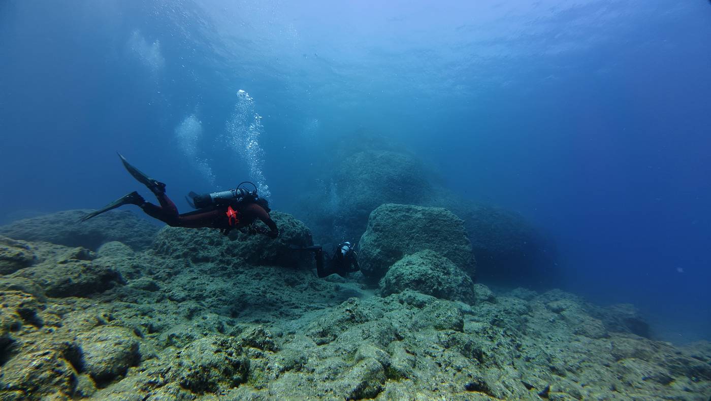 Potápěči v mělké vodě po vyplavání ze zátoky sv. Jana u pobřeží v Lindosu
