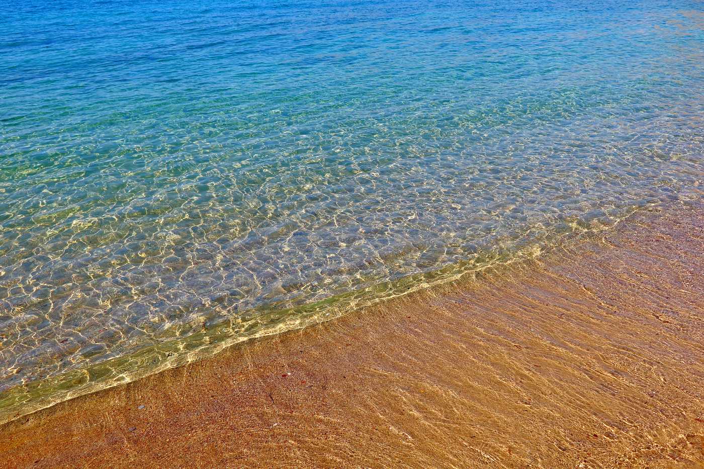 Klidná hladina a nádherná pláž Plakia se žlutým pískem, Rhodos Pefki.